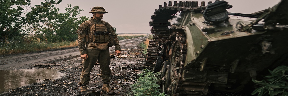 Ukrainian soldier at a tank wreckage