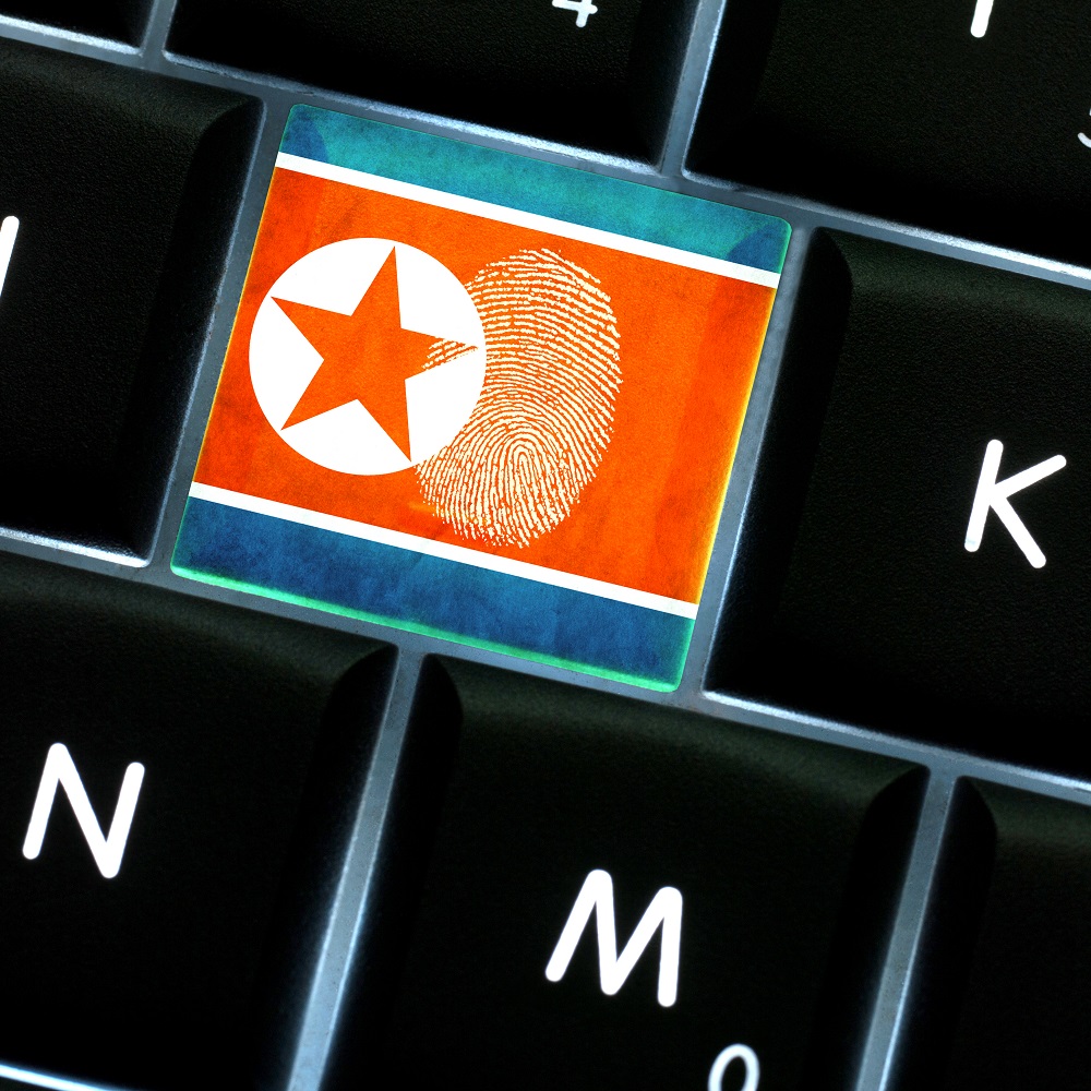 Online crime scene with a finger print left on backlit keyboard with North Korea flag on it