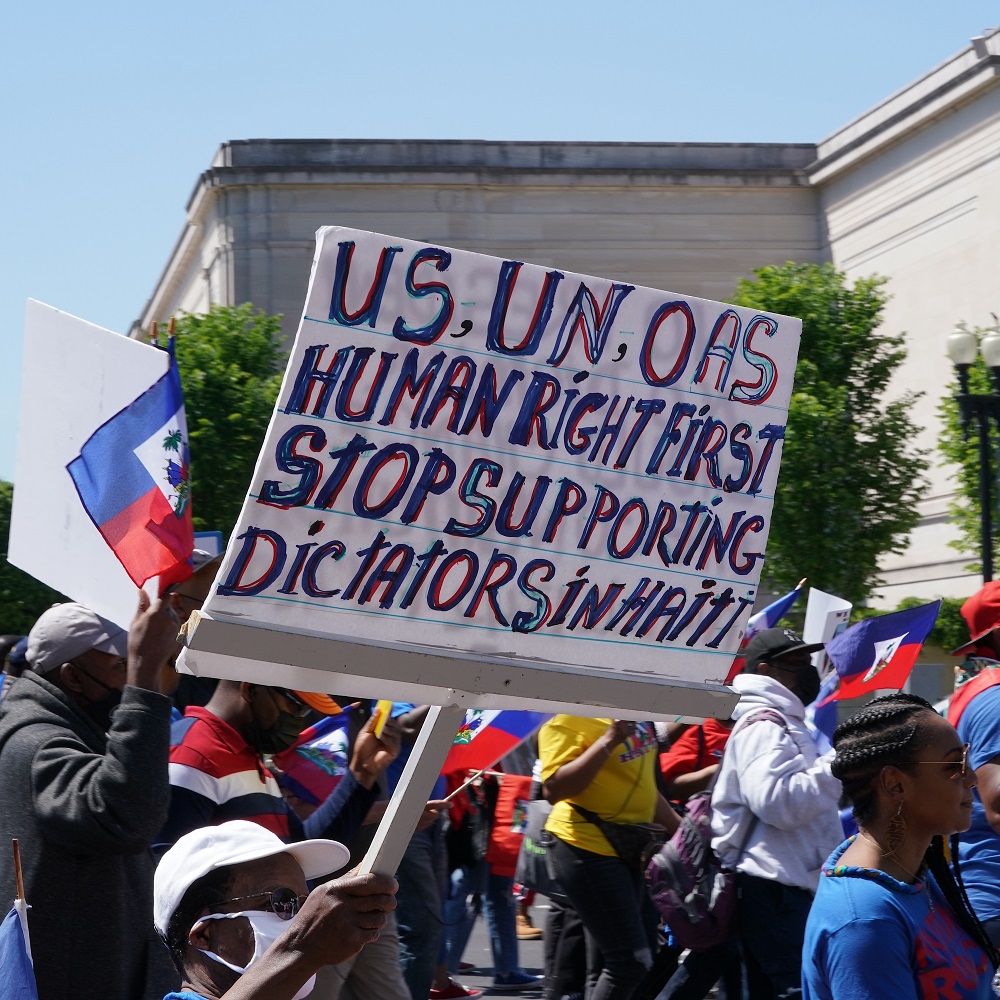 Demonstrators marching along Pennsylvania Avenue to the White House to encourage the Biden administration in ending its support of Haitian dictators
